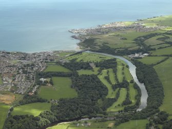 General oblique aerial view centred on the country house, golf course and road bridge with the towns adjacent, taken from the SW.