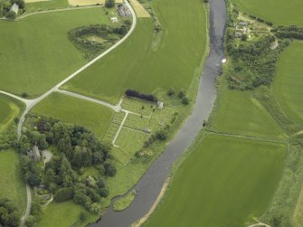 Oblique aerial view centred on the remains of the church and the burial-ground with the manse adjacent, taken from the WSW.