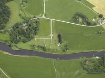 Oblique aerial view centred on the remains of the church and the burial-ground with the manse adjacent, taken from the SSW.