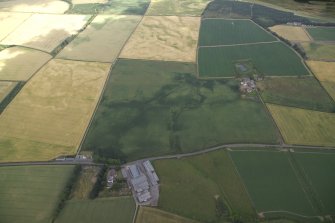 General oblique aerial view centred on the cropmarks of the enclosures with the farmsteadings and farmhouses adjacent, taken from the S.