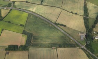 Oblique aerial view centred on the cropmarks of the Roman temporary camps and possible fort annexe, taken from the SSE.