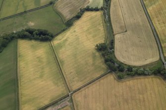 General oblique aerial view centred on the cropmarks of the ring-ditch, taken from the N.