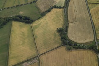 General oblique aerial view centred on the cropmarks of the ring-ditch, taken from the NNW.