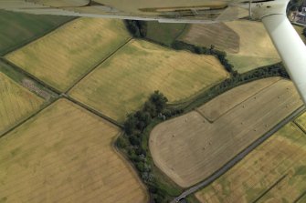 General oblique aerial view centred on the cropmarks of the ring-ditch, taken from the NW.
