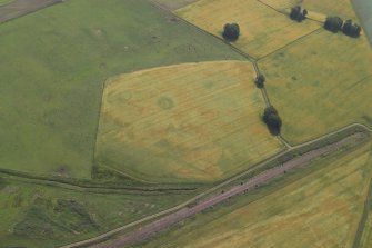 Oblique aerial view centred on the cropmarks of the enclosure and ring-ditch with the cropmarks of the Roman fort adjacent, taken from the WNW.