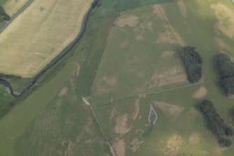 Oblique aerial view centred on the parchmarks of the Roman fort, taken from the SW.