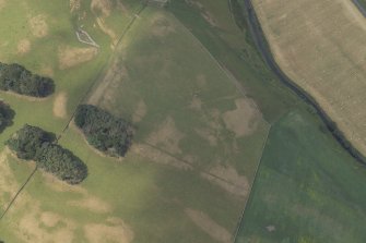 Oblique aerial view centred on the parchmarks of the Roman fort, taken from the E.