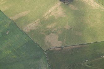 Oblique aerial view centred on the parchmarks of the Roman fort, taken from the NW.