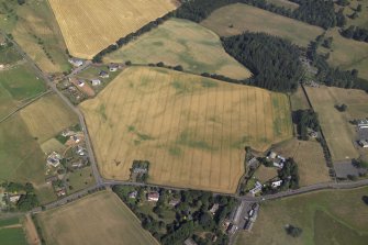 Oblique aerial view centred on the cropmarks of the enclosure, taken from the SE.