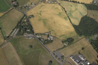 Oblique aerial view centred on the cropmarks of the enclosure, taken from the E.