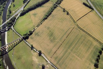 Oblique aerial view centred on the cropmarks of the Roman fort, Roman temporary camps and fort annexes, taken from the NW.