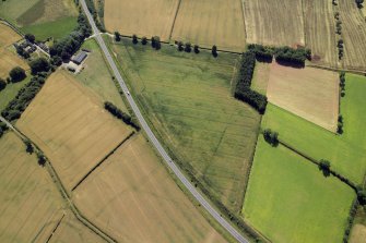 Oblique aerial view centred on the cropmarks of the Roman temporary camps and possible fort annexe, taken from the NW.