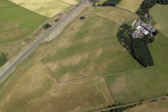 Oblique aerial view centred on the parchmarks and remains of the fort, taken from the SSW.