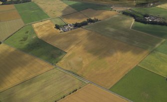 General oblique aerial view centred on the cropmarks of the rig and pits the farmhouse and farmsteading adjacent, taken from the N.