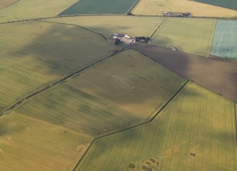 General oblique aerial view centred on the cropmarks of the fort with the farmhouse in the distance, taken from the SE.