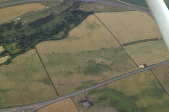 Oblique aerial view centred on the cropmarks of the fort, taken from the N.