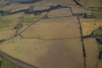 General oblique aerial view centred on the linear cropmarks with the cropmarks of the quarry, frost wedges, linear cropmarks, farmsteading and farmhouse adjacent, taken from the NNW.