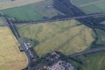 Oblique aerial view centred on the cropmarks of the cursus, ring-ditch and pits with the country house adjacent, taken from the NNW.