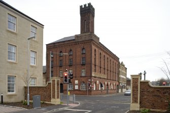 General view from SSE of paint works at 108-118 Tradeston Street, corner of Cook Street, note parapet, machiolation and lancets with Ghibelline crenellation of corner tower.