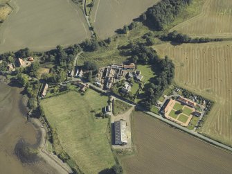 Oblique aerial view centred on the remains of the abbey and church and the farmsteading, taken from the WSW.