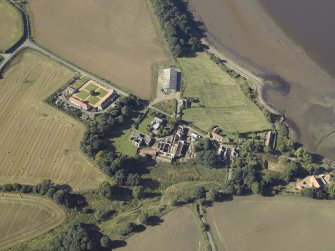Oblique aerial view centred on the remains of the abbey and church and the farmsteading, taken from the ENE.