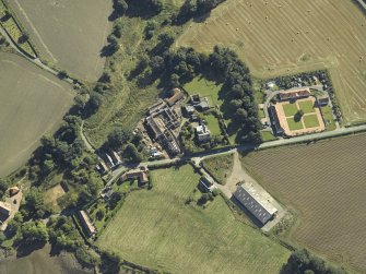 Oblique aerial view centred on the remains of the abbey and church and the farmsteading, taken from the WNW.