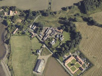 Oblique aerial view centred on the remains of the abbey and church and the farmsteading, taken from the SW.