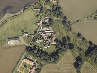 Oblique aerial view centred on the remains of the abbey and church and the farmsteading, taken from the SE.