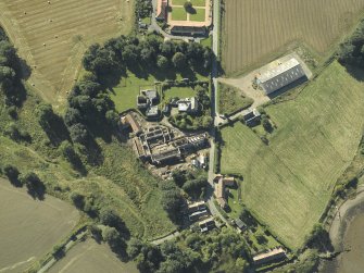 Oblique aerial view centred on the remains of the abbey and church and the farmsteading, taken from the N.