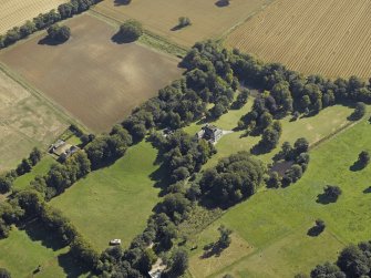 Oblique aerial view centred on the country house, gardens and the stables, taken from the NW.