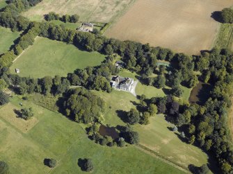 Oblique aerial view centred on the country house, gardens and the stables, taken from the SW.