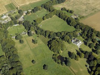 Oblique aerial view centred on the country house, gardens and the stables, taken from the SSW.