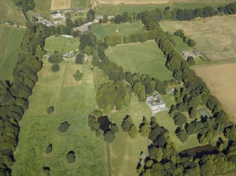 Oblique aerial view centred on the country house, gardens and the stables, taken from the SSE.