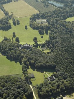 General oblique aerial view centred on the country house with the stable in the foreground and the walled garden in the distance, taken from the N.