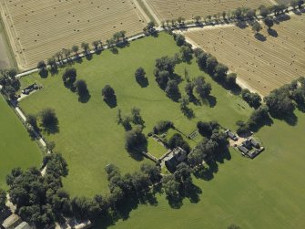 Oblique aerial view centred on the tower-house, dovecot, gardens and stable block, taken from the N.