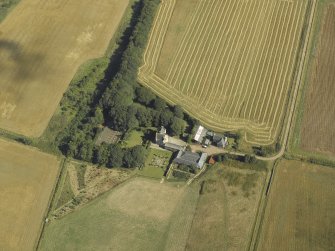 Oblique aerial view centred on the farmhouse, farmsteading and tower-house, taken from the SW.