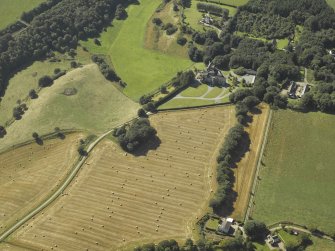 Oblique aerial view centred on the country house, dovecot, summerhouse, gate-lodge and walled garden, taken from the NE.