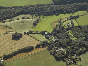 Oblique aerial view centred on the country house, dovecot, summerhouse, gate-lodge and walled garden, taken from the N.