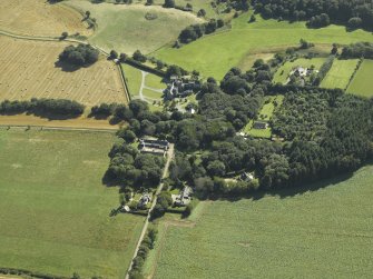 Oblique aerial view centred on the country house, dovecot, summerhouse, gate-lodge and walled garden, taken from the NW.