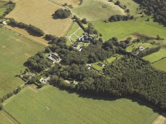 Oblique aerial view centred on the country house, dovecot, summerhouse, gate-lodge and walled garden, taken from the WNW.