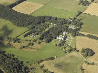 General oblique aerial view centred on the country house, dovecot, summerhouse, gate-lodge and walled garden, taken from the SE.