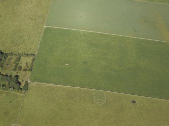 Oblique aerial view centred on the remains of the cairn and stone circle with the remains of the recumbent stone circle adjacent, taken from the SSE.