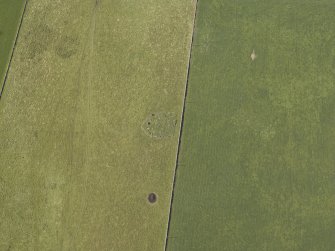 Oblique aerial view centred on the remains of the cairn and stone circle, taken from the E.