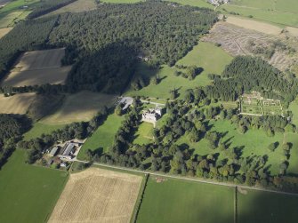 General oblique aerial view centred on the tower-house and remains of the chapel with the farmhouse, farmsteading and walled garden adjacent, taken from the SE.