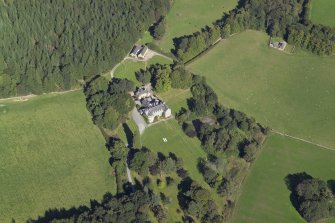 Oblique aerial view centred on the country house, hotel and hall-house with the cottage adjacent, taken from the SW.