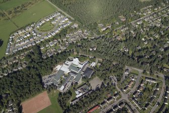 General oblique aerial view centred on the church and the school, taken from the SW.