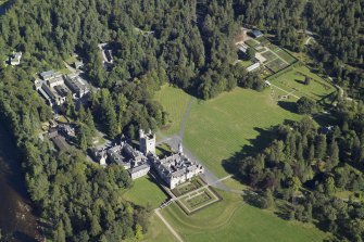 Oblique aerial view centred on the country house and garden with the cottages, kennels and walled garden adjacent, taken from the W.