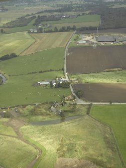 General oblique aerial view centred on the site of the Roman fort and the course of the Antonine Wall with the brickworks adjacent, taken from the WSW.
