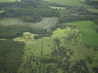 General oblique aerial view centred on the remains of the Roman fort and the course of the Antonine Wall with the remains of the fort adjacent, taken from the NW.