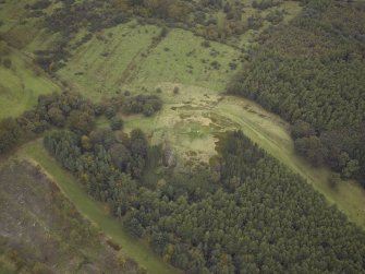 Oblique aerial view centred on the remains of the fort with the course of the Antonine Wall adjacent, taken from the ESE.